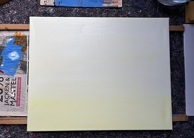 Die Leinwand lasierend mit weisser und zitronengelber Farbe grundiert